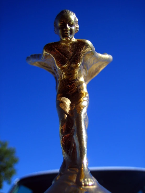 the golden statue stands in front of a blue sky