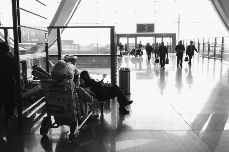 black and white po of people sitting on chairs at an airport