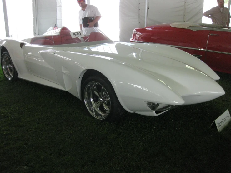 a white car parked inside of a tented building