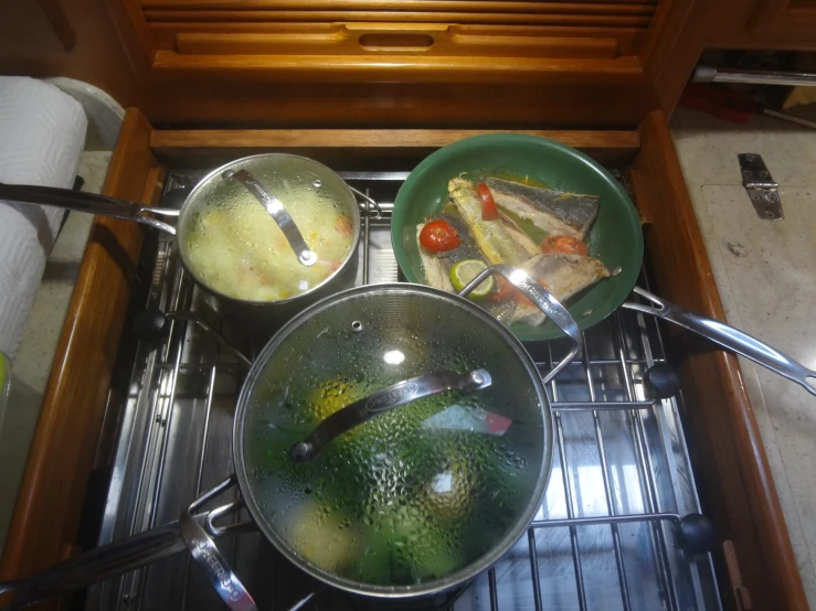 three pans are cooking food on the stove