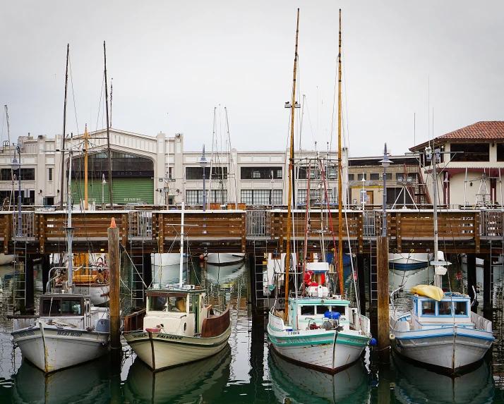 three boats that are docked on some water