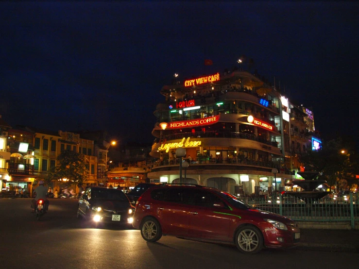 several cars at night with colorful neon lights on