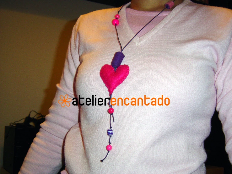 a woman in a white sweater with a pink heart