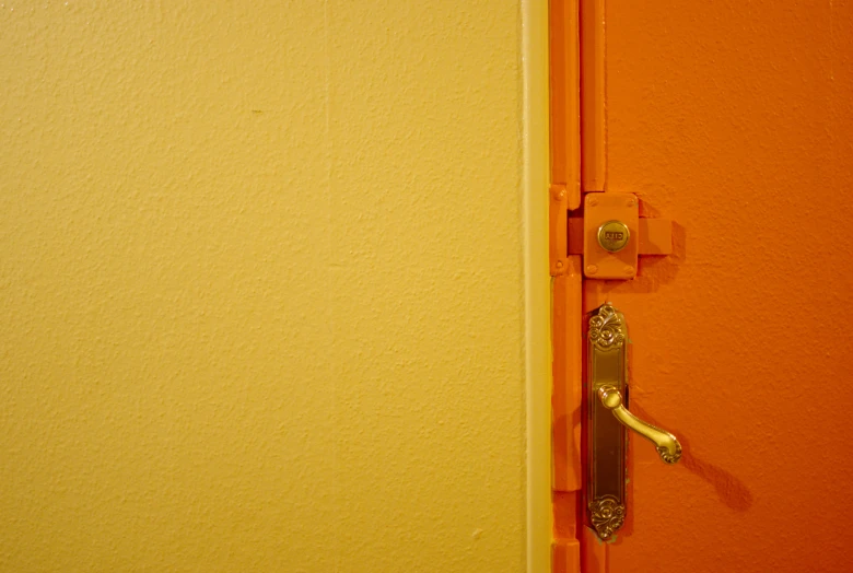 an orange wall that has an open door