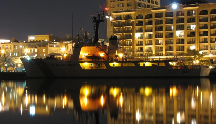 a boat is docked at night with many lights in it