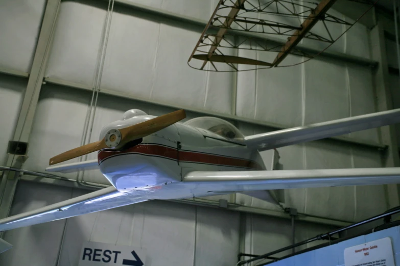 a prop plane is hanging upside down in a hangar