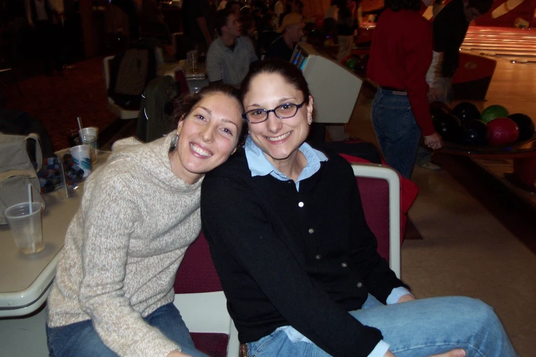 two women pose for a po while sitting down