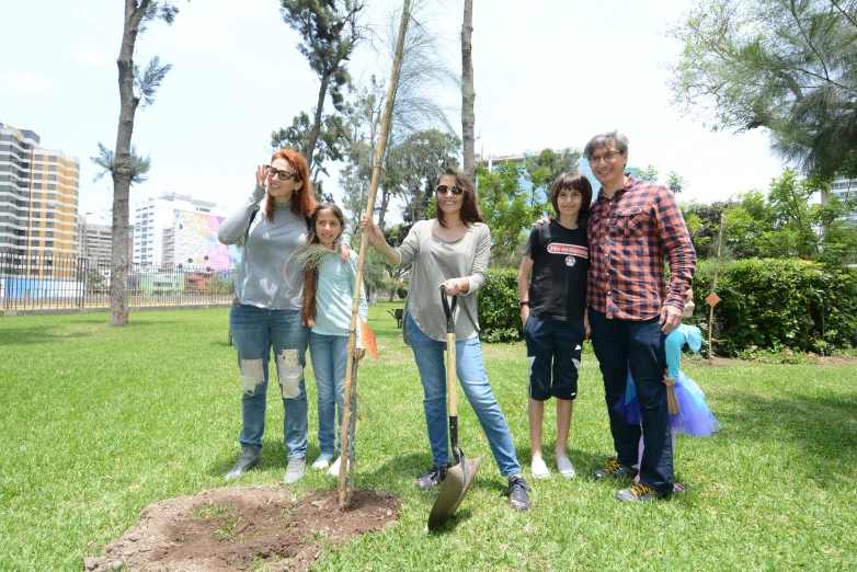 the family is posing for a picture in the park