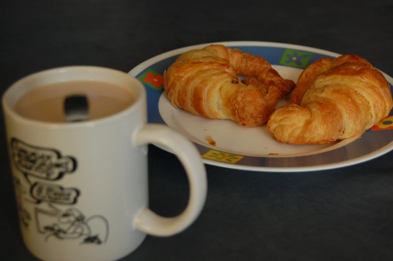 some croissants sit next to a coffee mug