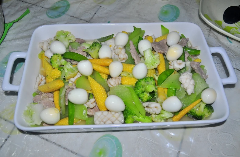 a white dish filled with a vegetable salad