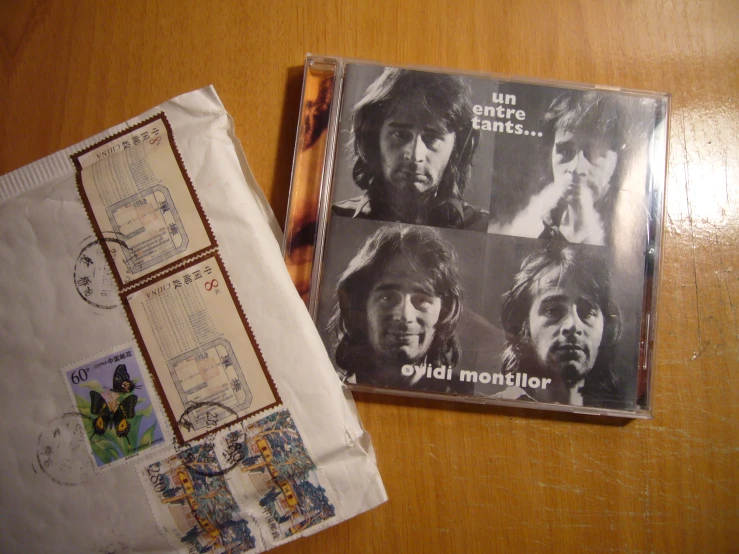 two mail - sealed envelopes, one containing a po of the rolling stones and the other with a postage stamp, are left behind a piece of a hand - made in