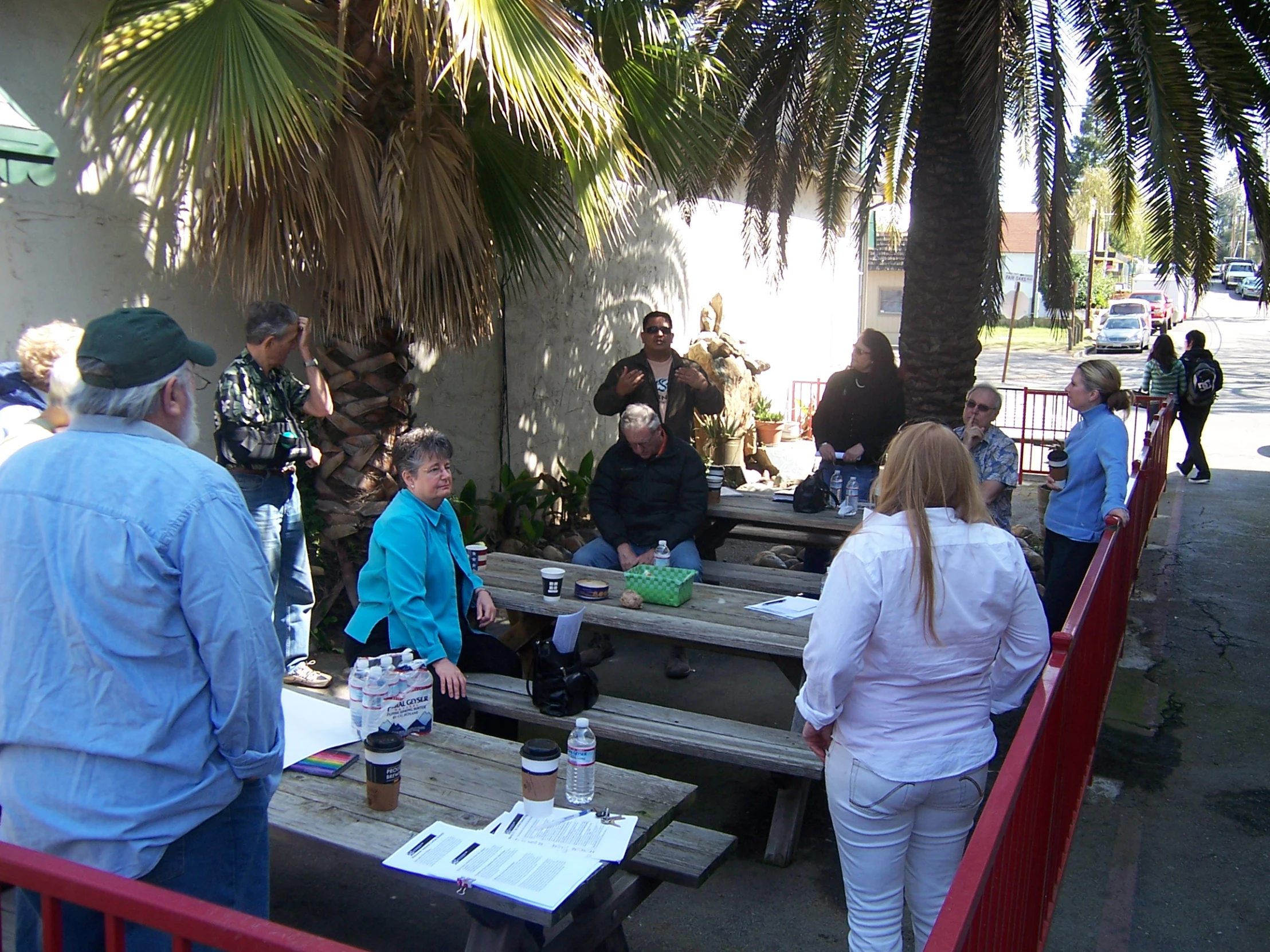 a group of people standing around tables at an outdoor gathering