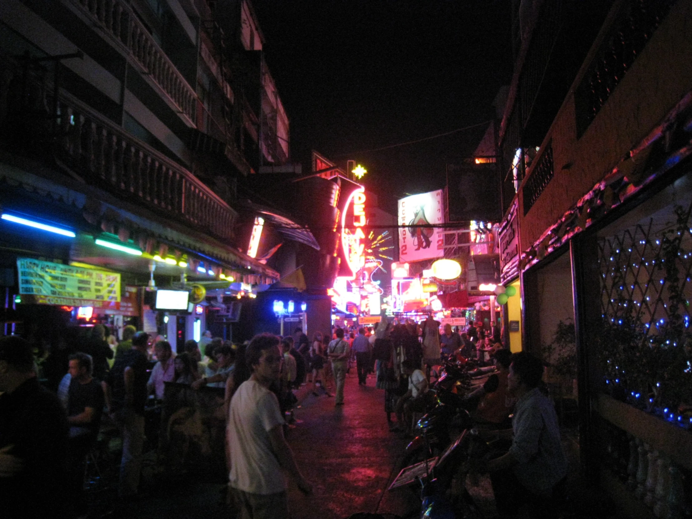 a nighttime po of people walking around an asian city