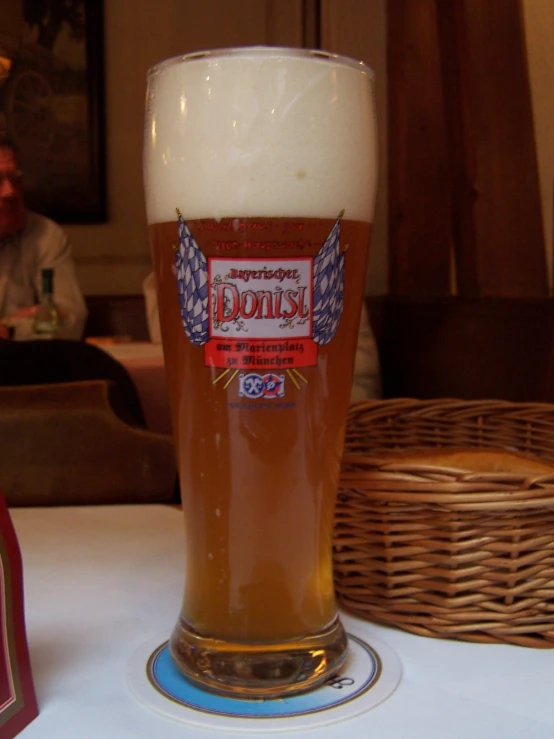 a big glass with some beer sitting on the table