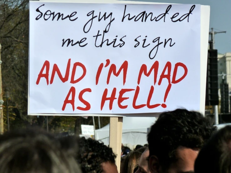 a sign that is in the middle of a crowd