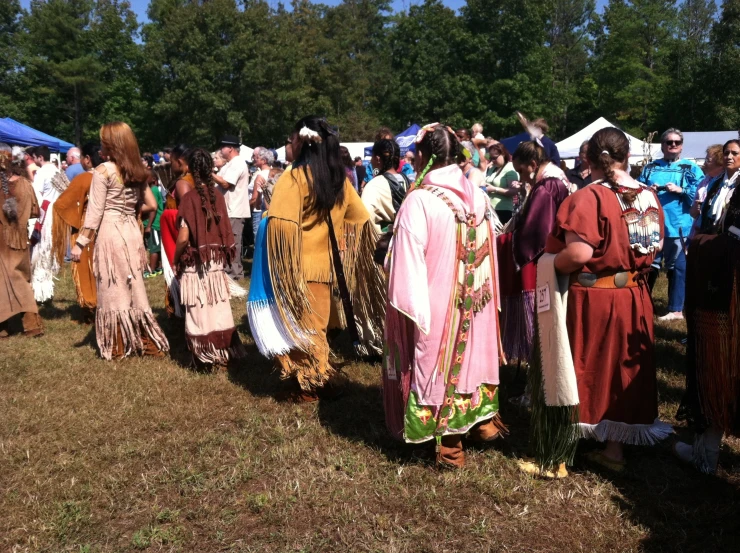 several men and women in native costume in front of a crowd