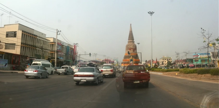 several cars driving down an intersection near tall buildings