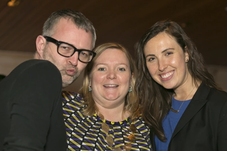 three people posing for a picture next to one another