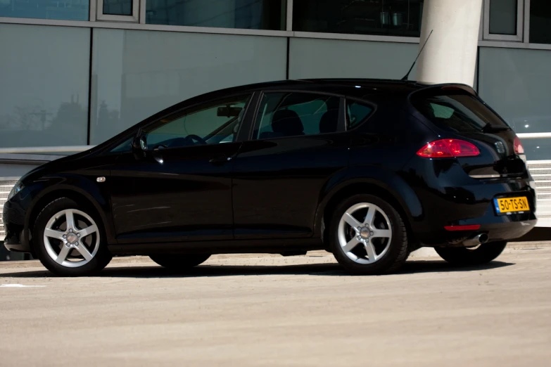 the black small car is parked in front of the building