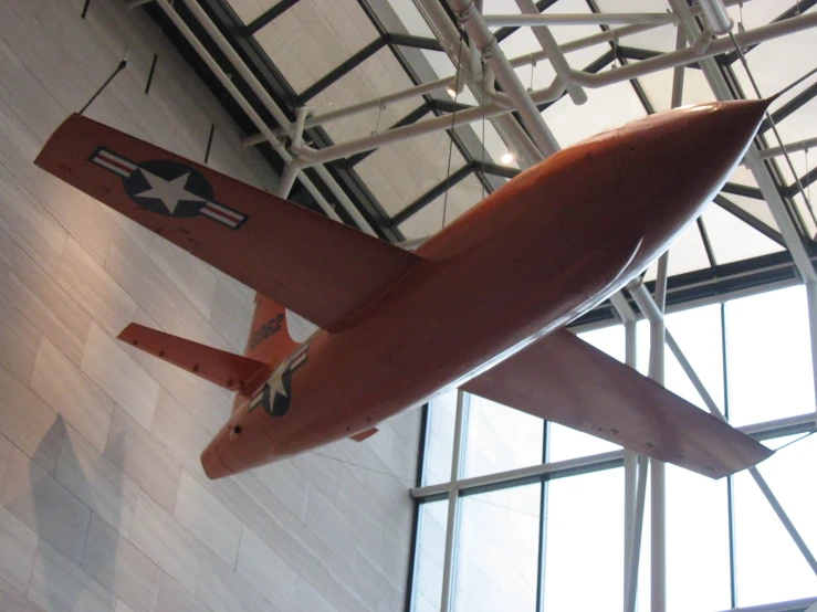 a red airplane suspended in an air hanger