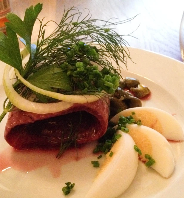 a white plate topped with vegetables and meat