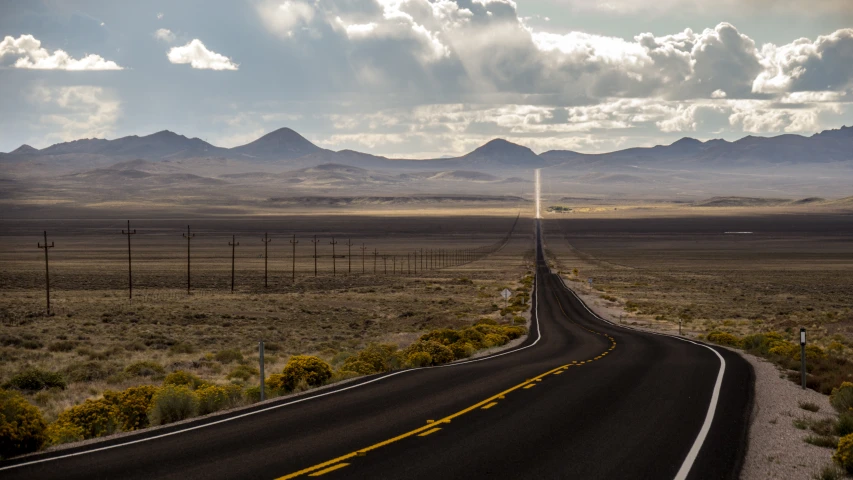 a long stretch of road stretches through the desert