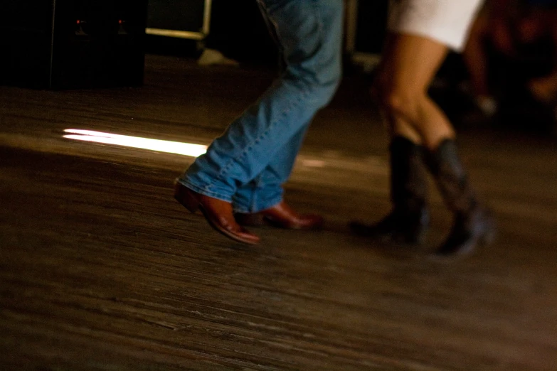 two people are standing on the floor, each with a boot on top of their feet