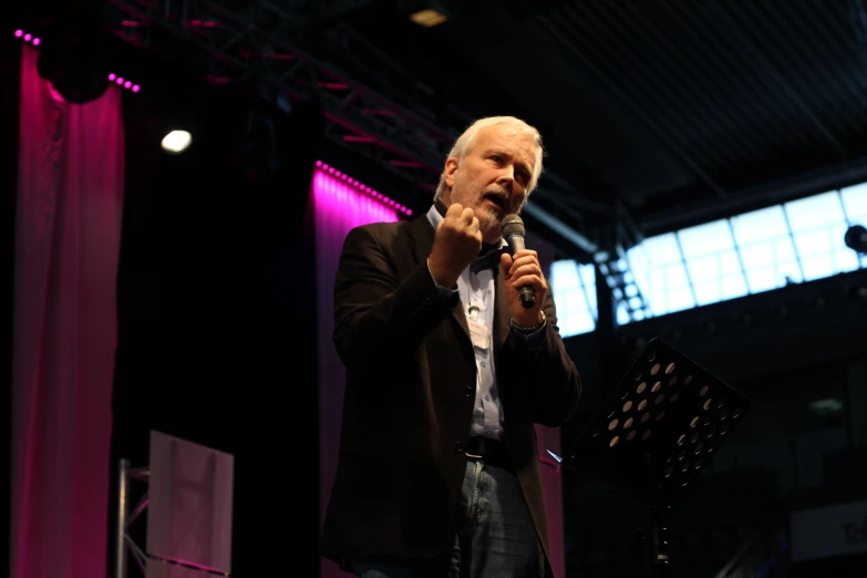 a man standing at a microphone while holding a mic