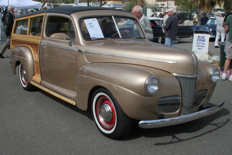 an antique car is displayed in a parking lot