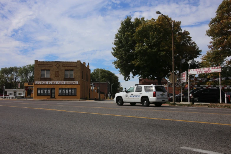 truck parked in front of small shop on street corner