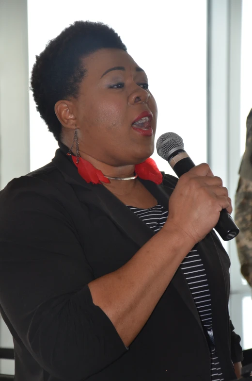 a woman in uniform stands and speaks into a microphone