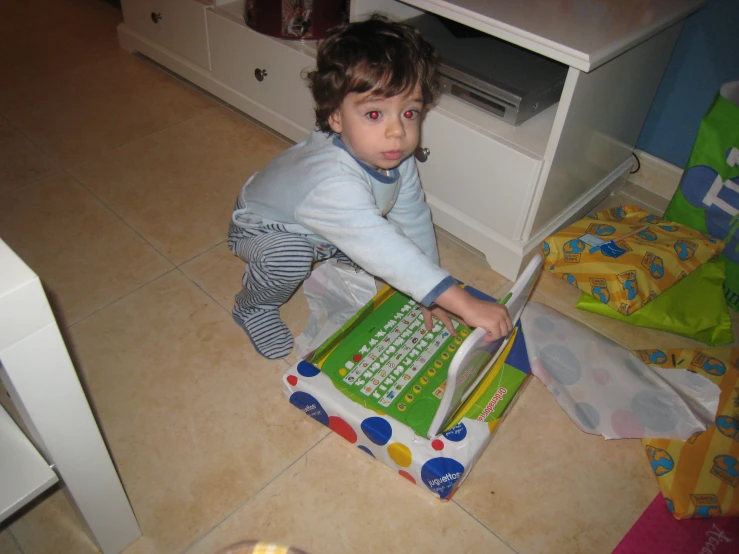 young child using computer with colorful mouse mat on floor