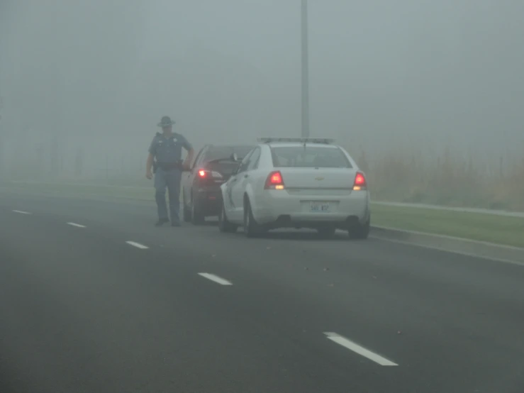 a police car and two cars on a highway