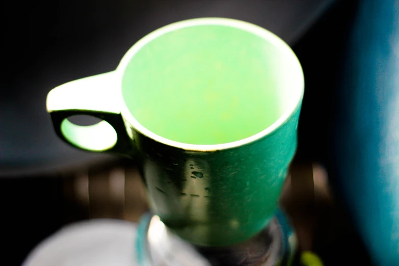 a green mug with a curved handle is pictured