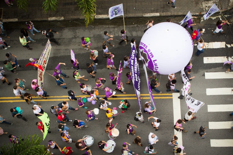 people walking and walking down a road with balloons