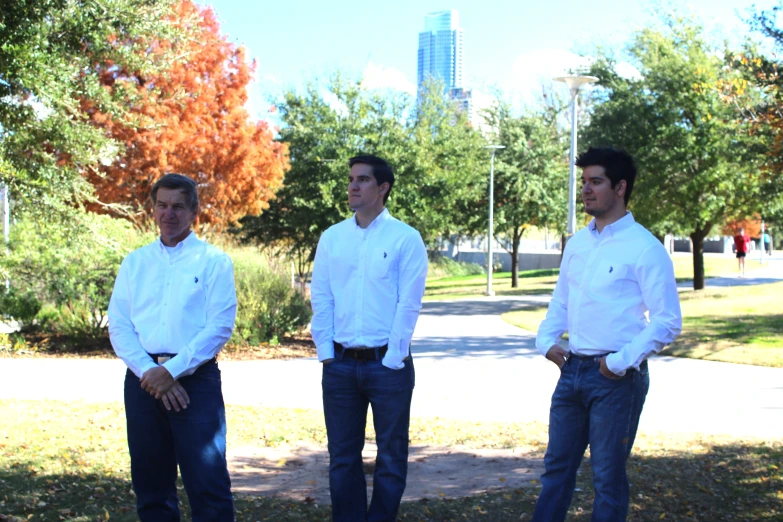 four males are standing in front of trees