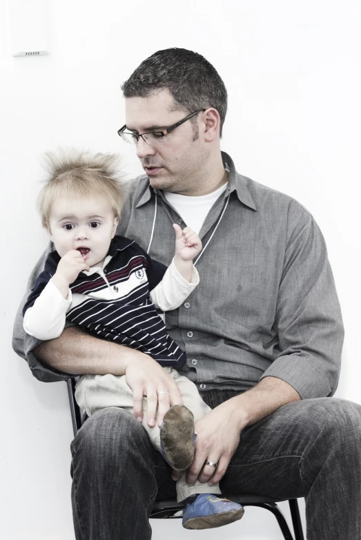 a man and a baby sitting in a chair