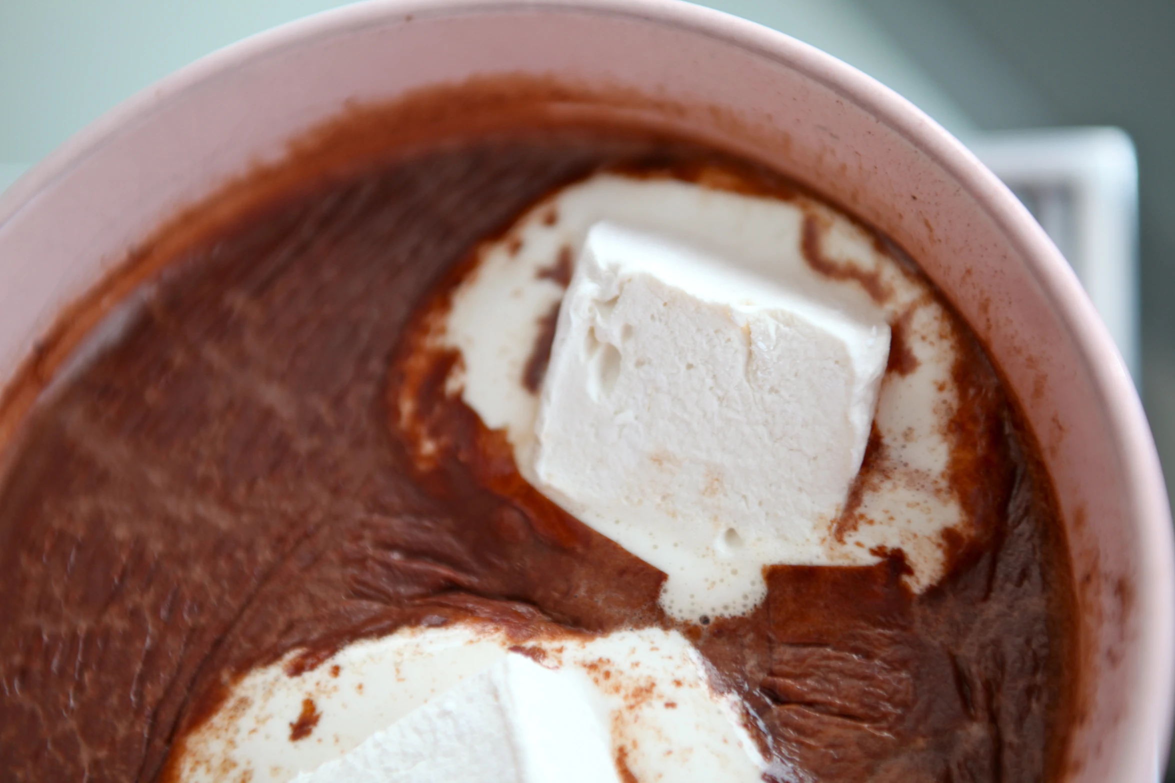 a bowl filled with chocolate ding, marshmallows and cocoa