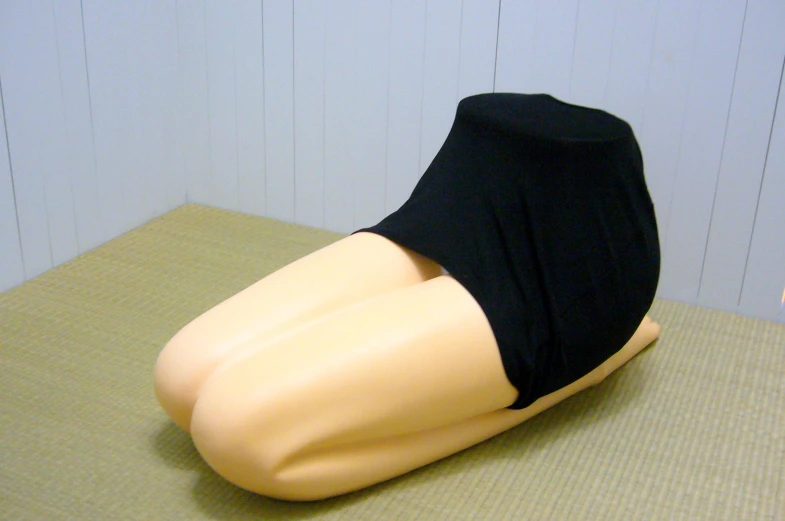 a mannequin is sitting on the table in black cloth