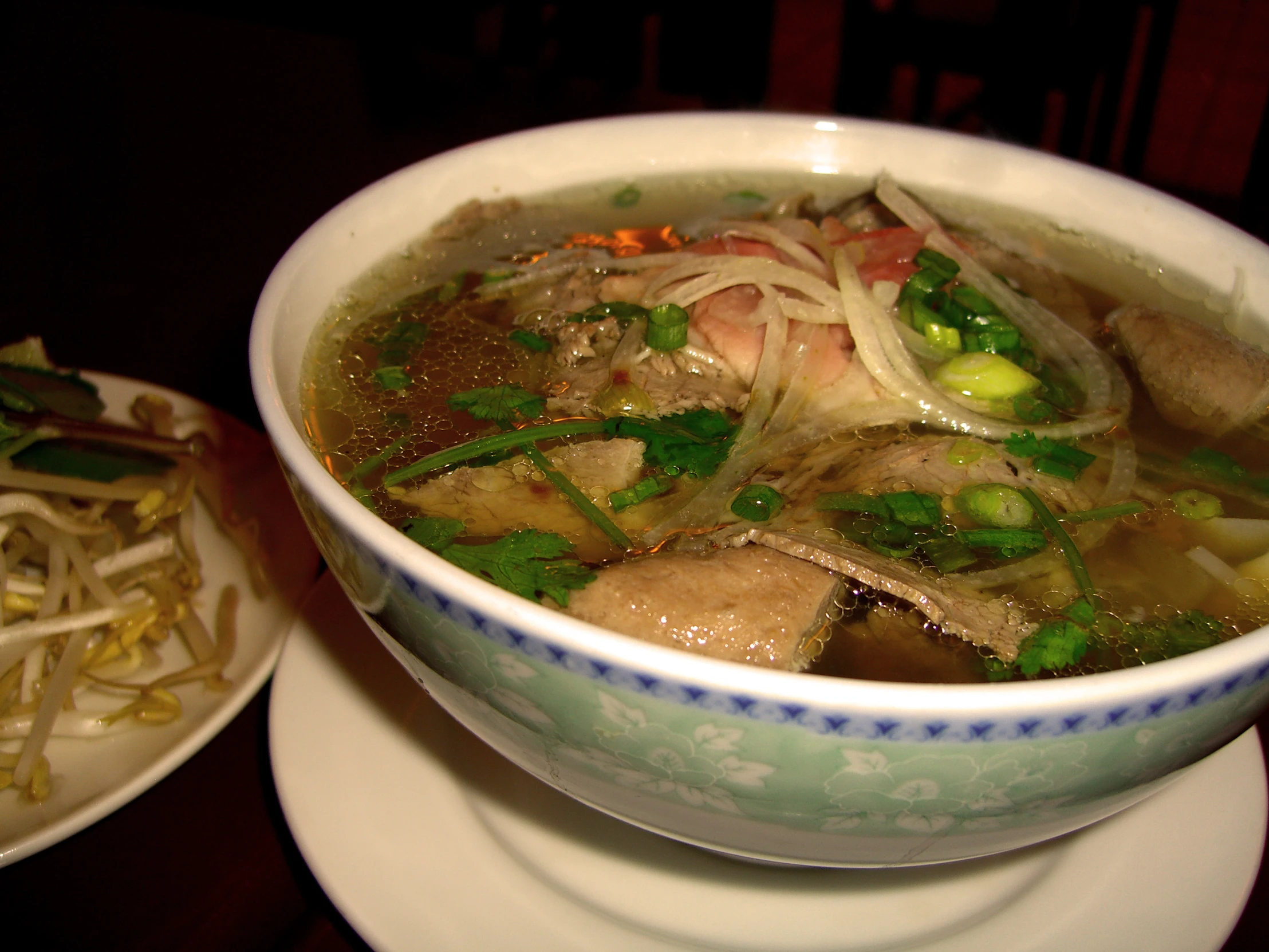 two plates of food that includes soup, vegetables and fish