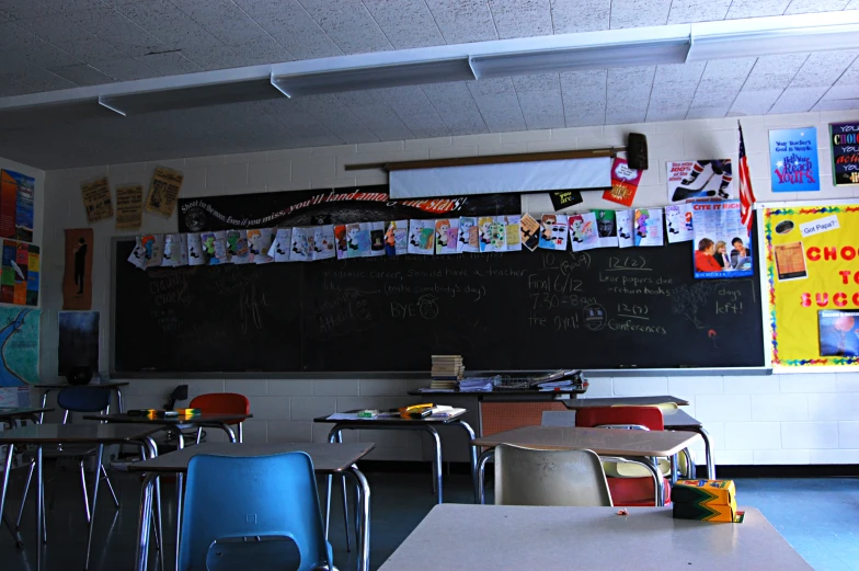 a classroom with chalkboard and chairs in front of it