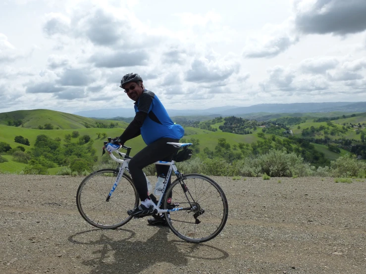 a person in blue jacket riding a bike on top of a hill