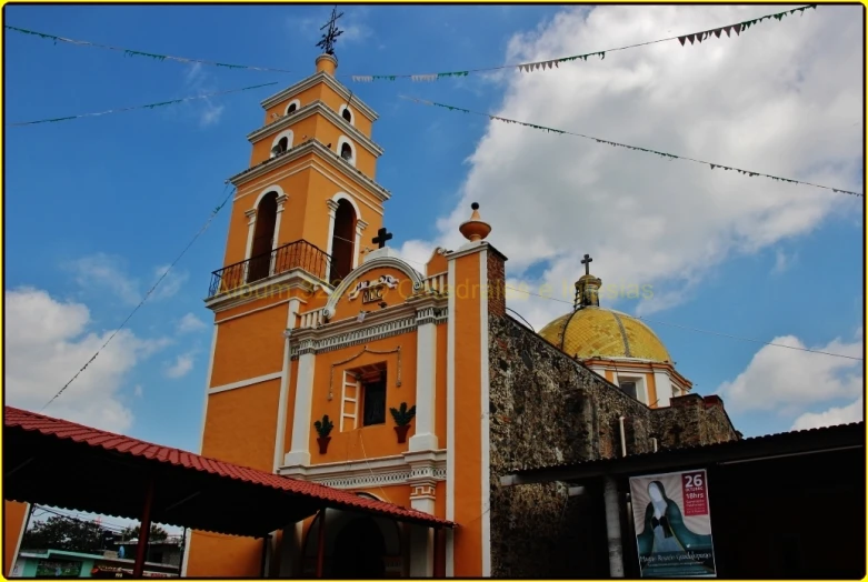 a large orange building with a bell tower under a cloudy sky