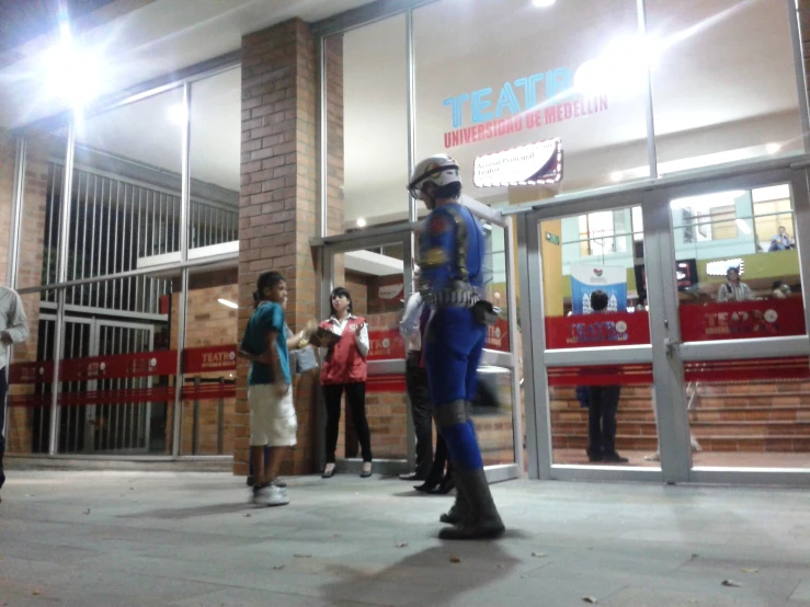 three men in blue uniform are standing outside the theater