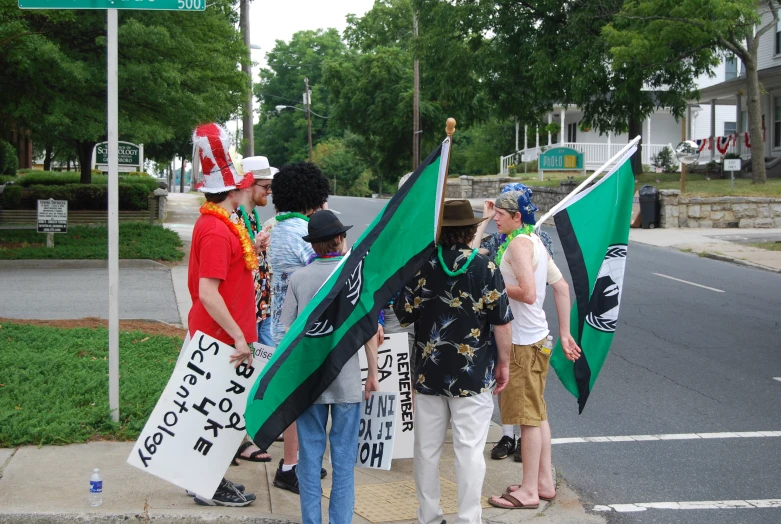 group of people stand in the street with flags and banners