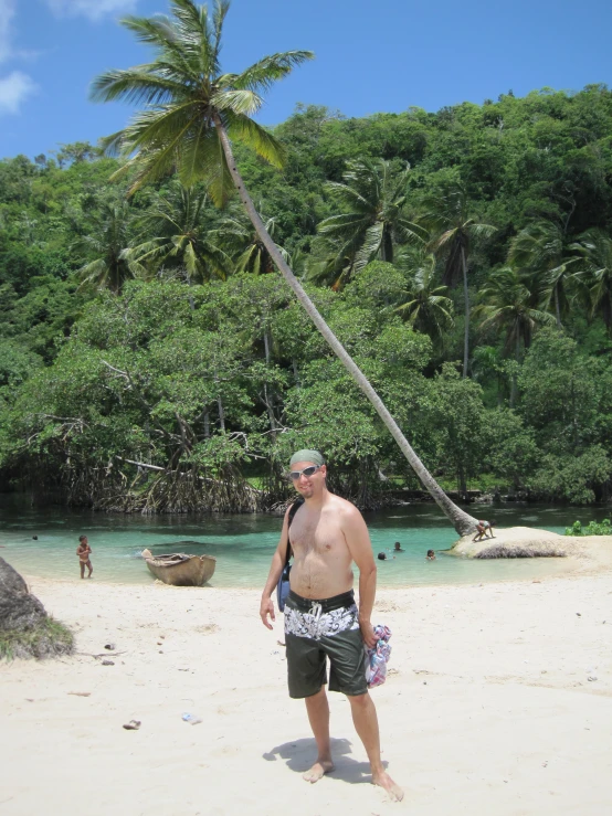 a man is standing on the beach with a large surfboard