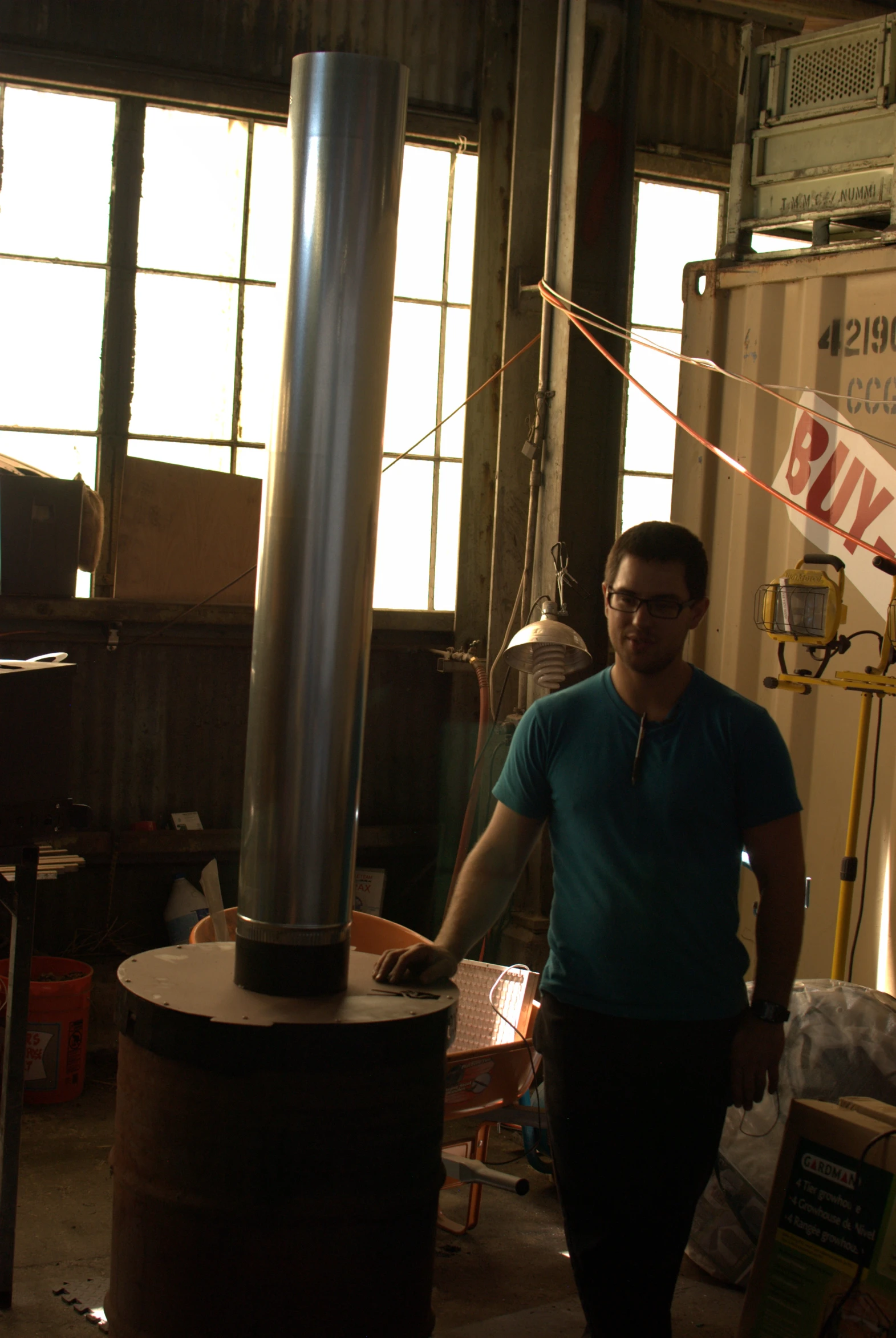 a man in a blue shirt is standing near a machine