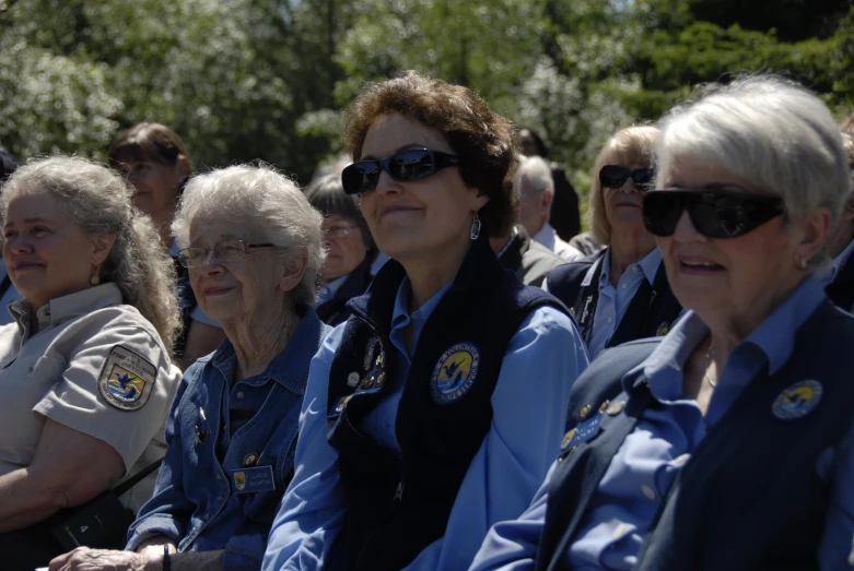 elderly women wearing sunglasses are sitting next to each other