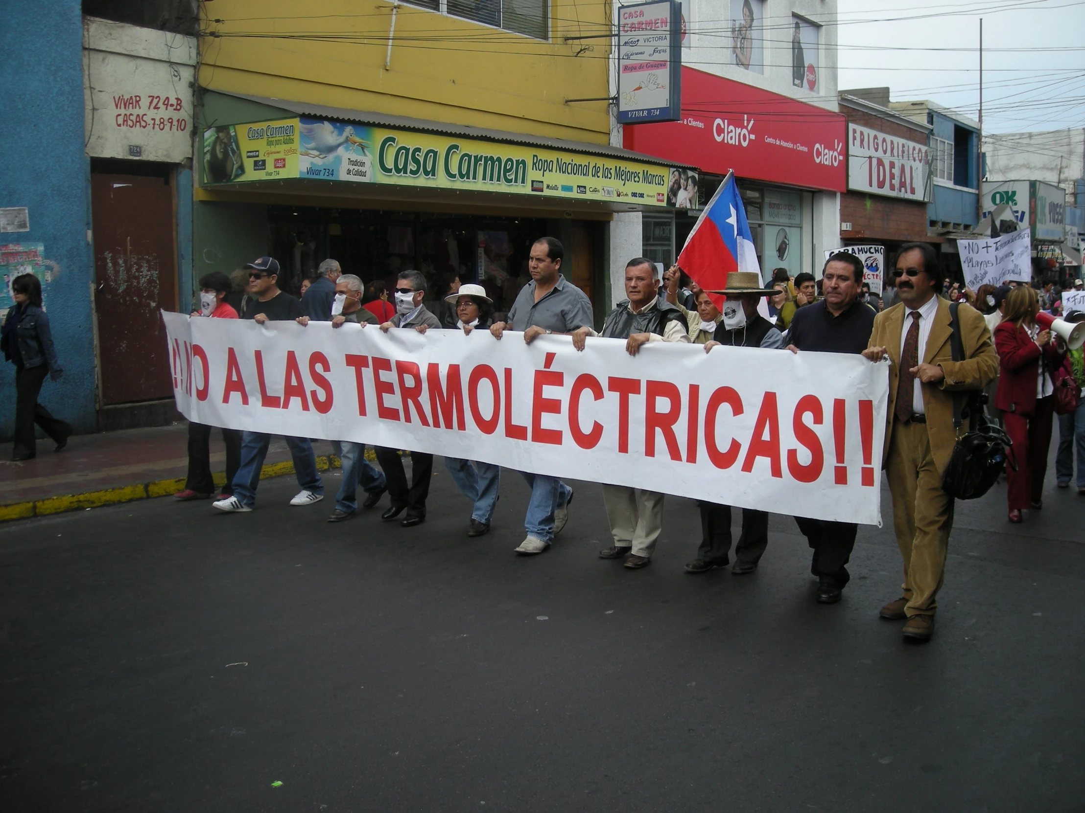 people on the street with protest signs in spanish