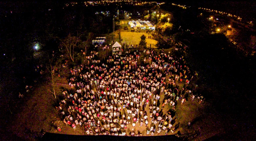 an aerial view of a crowd at night with some lights in the sky